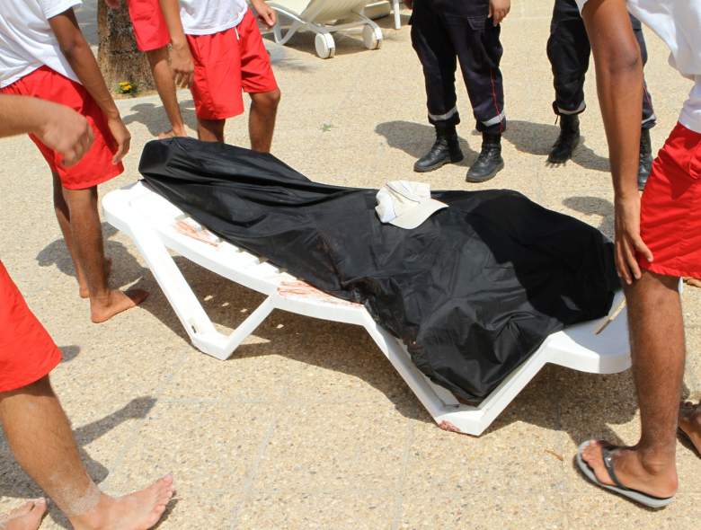 Salvavidas rodean el cuerpo sin vida bajo una manta negra en la playa en Túnez.  (Foto deBECHIR TAIEB/AFP/Getty Images)