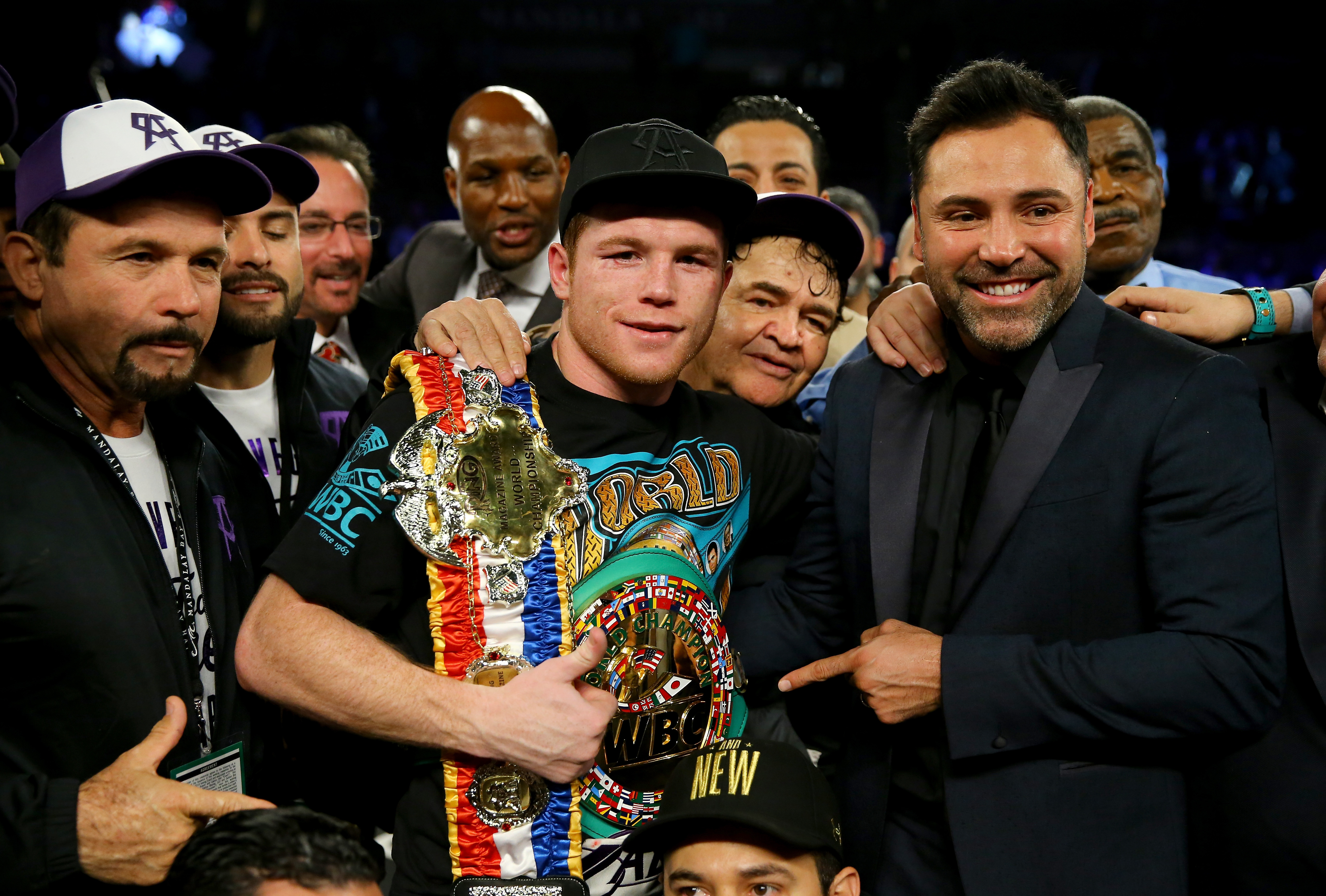 Canelo Alvarez celebra con el promotor Oscar De La Hoya después de derrotar a Miguel Cotto por decisión unánime en su pelea de peso mediano. (Getty) 