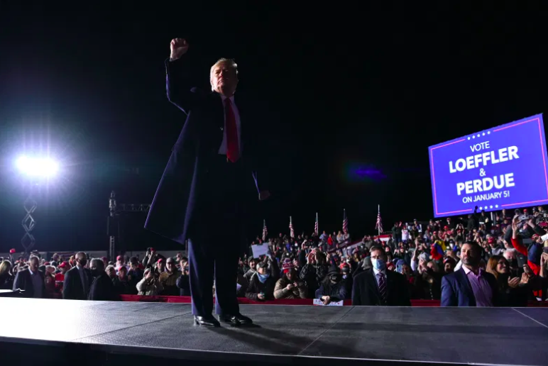 Trump levanta el puño después de hablar durante un mitin.