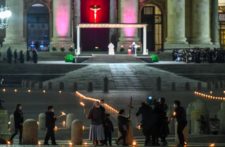 Los niños y jóvenes de Roma observan el Vía Crucis dirigido por el Papa Francisco (Posterior C) como parte del Viernes Santo el 2 de abril de 2021 en la plaza de San Pedro en el Vaticano.