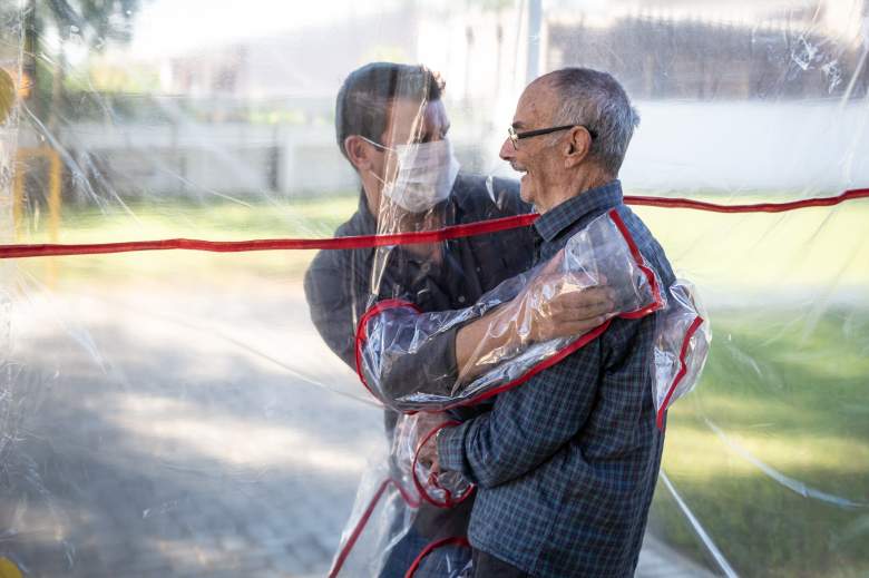 Un hijo abraza a su padre en la Clínica Geriátrica Três Figueiras el 16 de junio de 2020 en Gravatai, Brasil.