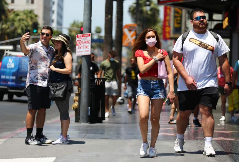 La gente camina y toma fotos en Hollywood Boulevard el 15 de junio de 2021 en Los Ángeles, California. California, el primer estado de los EE. UU. Que entró en bloqueo al comienzo de la pandemia de coronavirus, está levantando casi todas las restricciones de COVID-19 hoy, con la excepción del uso de máscaras y el distanciamiento social en el transporte público, hospitales, escuelas K-12 en interiores y algunas tiendas minoristas.