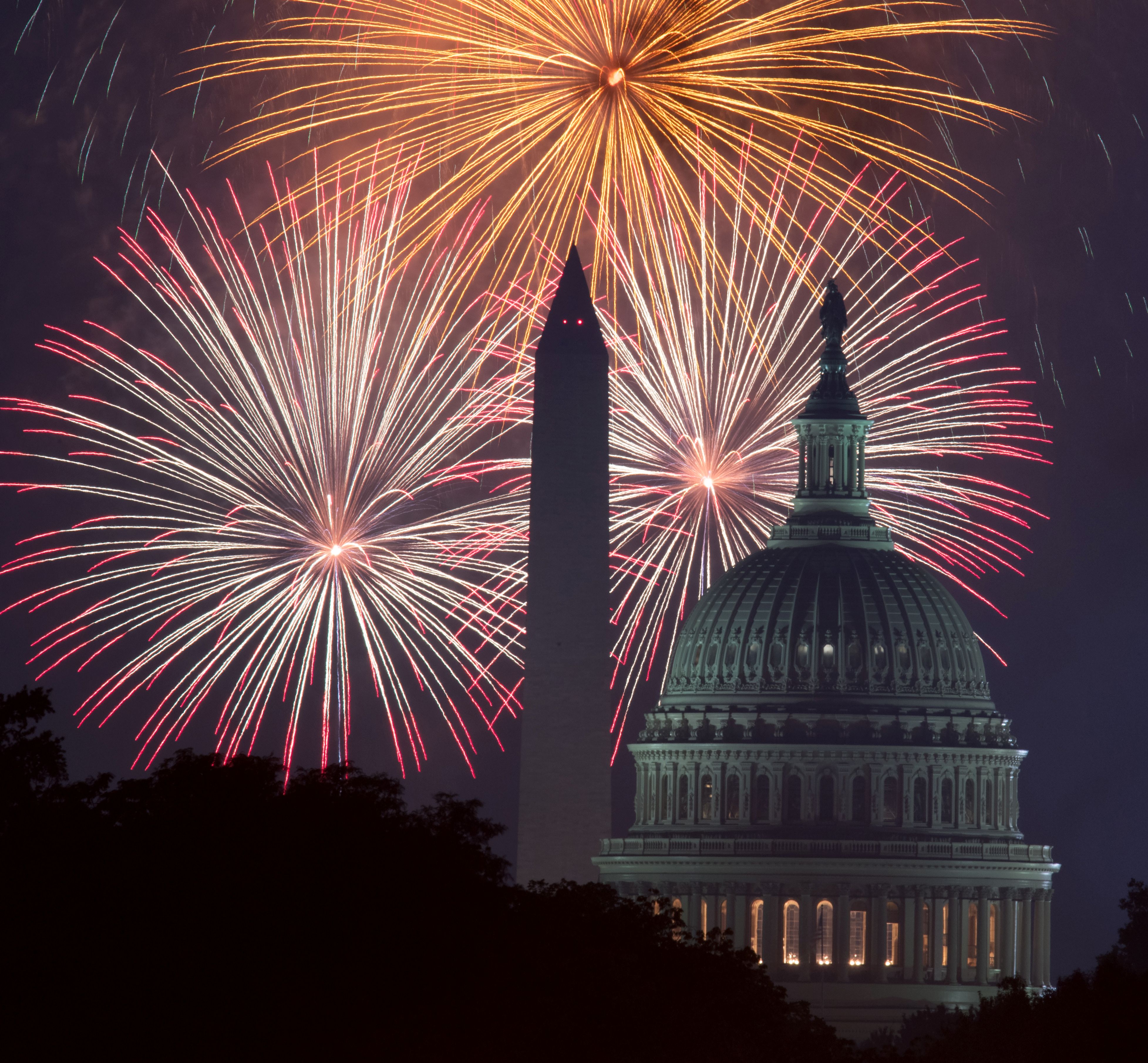 Los fuegos artificiales explotan sobre el National Mall en Washington, DC, mientras el Capitolio de los Estados Unidos (R) y el Monumento Nacional (C) se ven el 4 de julio de 2017 en Washington, DC.