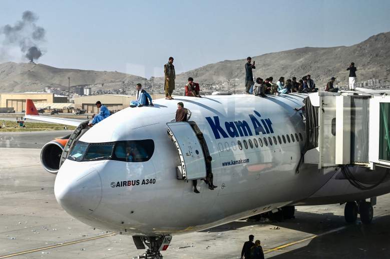 Los afganos se suben a un avión mientras esperan en el aeropuerto de Kabul el 16 de agosto de 2021, después de un final asombrosamente rápido de la guerra de 20 años de Afganistán