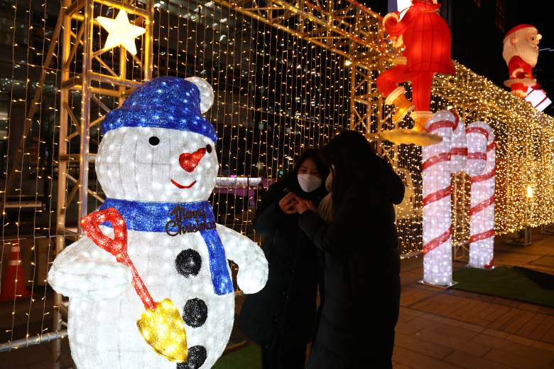 Los surcoreanos toman un selfie con iluminaciones navideñas el 17 de diciembre de 2021 en Seúl, Corea del Sur.