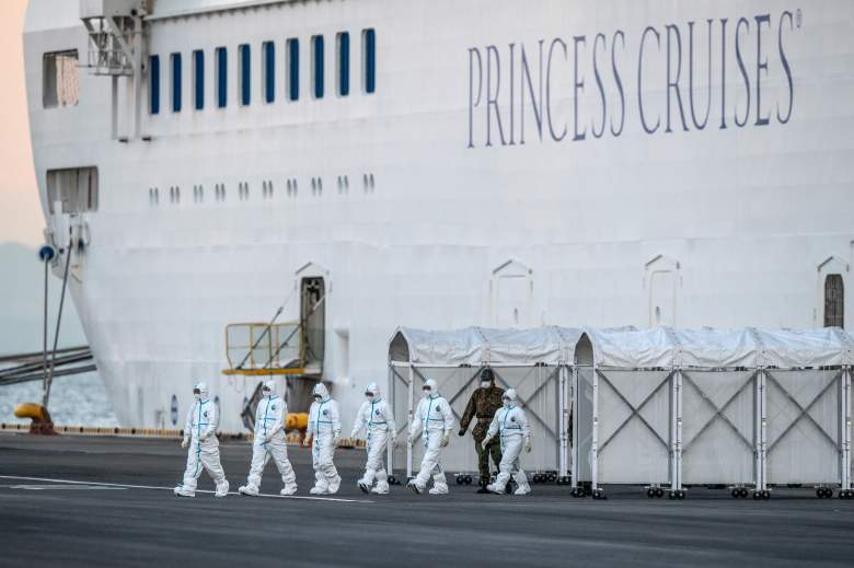 Los trabajadores de emergencia con ropa protectora salen del crucero Diamond Princess en el muelle de Daikoku donde se está reabasteciendo y los casos de coronavirus