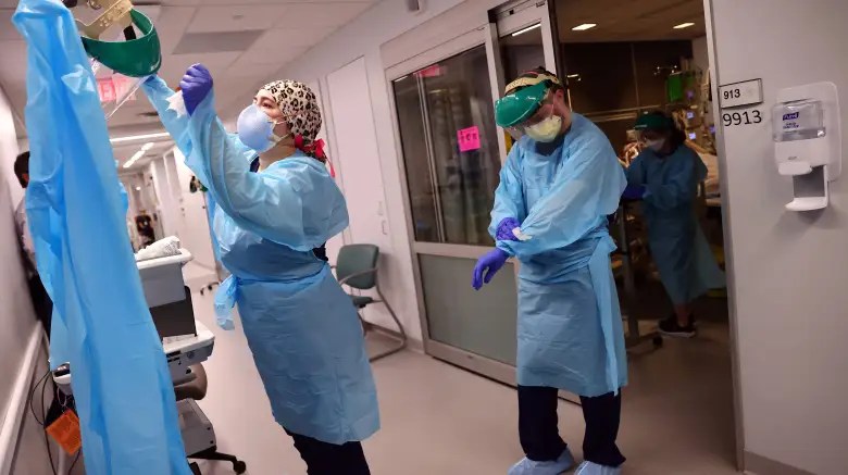 Los médicos abandonan la habitación de un paciente después de volver a colocar a un paciente con COVID-19 en posición supina en la Unidad de Cuidados Intensivos (UCI) del Lake Charles Memorial Hospital el 10 de agosto de 2021 en Lake Charles, Louisiana.