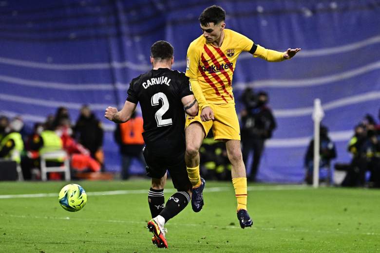 El defensor español del Real Madrid, Dani Carvajal (L), compite con el centrocampista español del Barcelona, Pedri, durante el partido de fútbol de la Liga española entre el Real Madrid CF y el FC Barcelona en el estadio Santiago Bernabeu de Madrid el 20 de marzo de 2022.