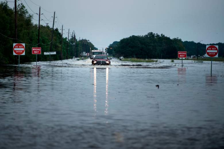 Los camiones se abren camino a través de las aguas de la inundación en una carretera principal que conduce a la planta química Arkema Inc.