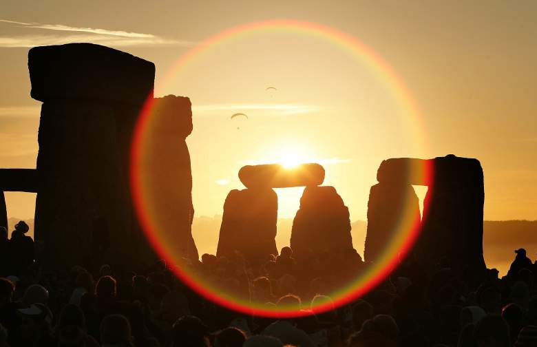 La gente mira el sol de verano mientras se eleva sobre el monumento megalítico de Stonehenge el 21 de junio de 2005 en la llanura de Salisbury, Inglaterra.