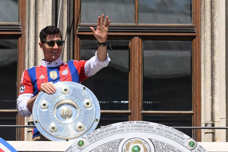 El delantero polaco del Bayern de Múnich, Robert Lewandowski, saluda desde un balcón con el trofeo de la victoria de la temporada de la Bundesliga en el centro de Múnich, el 15 de mayo de 2022, un día después del último partido de la temporada.